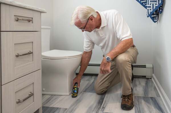 Home inspector using a moisture meter to check for water intrusion